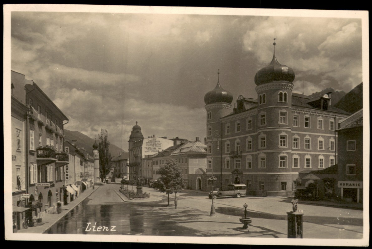 vergrößern: Bildseite historische Ansichtskarte von 1929: Straßenszene Bus Geschäfte:: Lienz