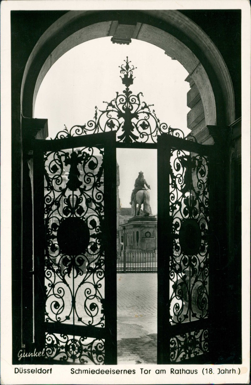 vergrößern: Bildseite historische Ansichtskarte von 1956: Schmiedeeisernes Tor am Rathaus - Blick zum Denkmal:: Düsseldorf