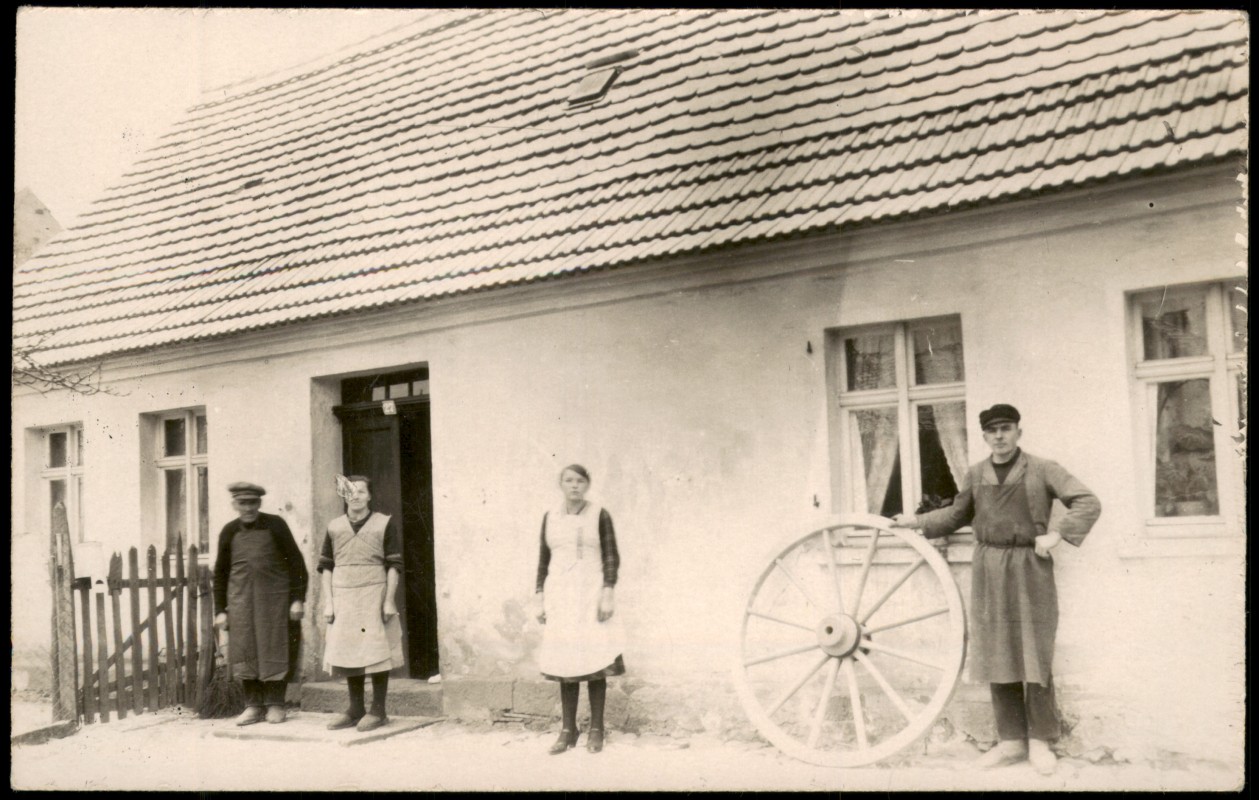 zoom: Image side vintage Postcard from 1928: Stellmacher mit Wagenrad vor seinem Wohnhaus::