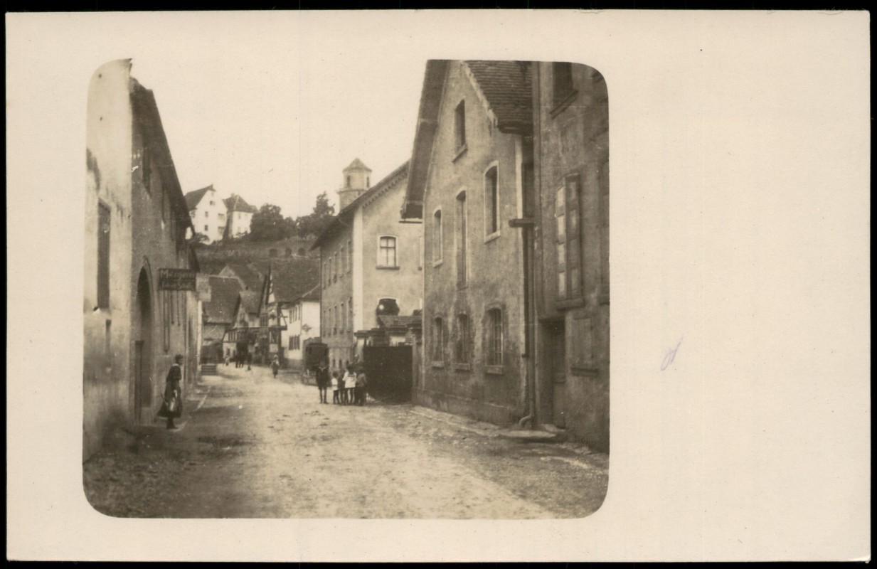 vergrößern: Bildseite historische Ansichtskarte von 1910: Belebte Dorfstraße mit historischer Architektur und Turm:: Schrozberg
