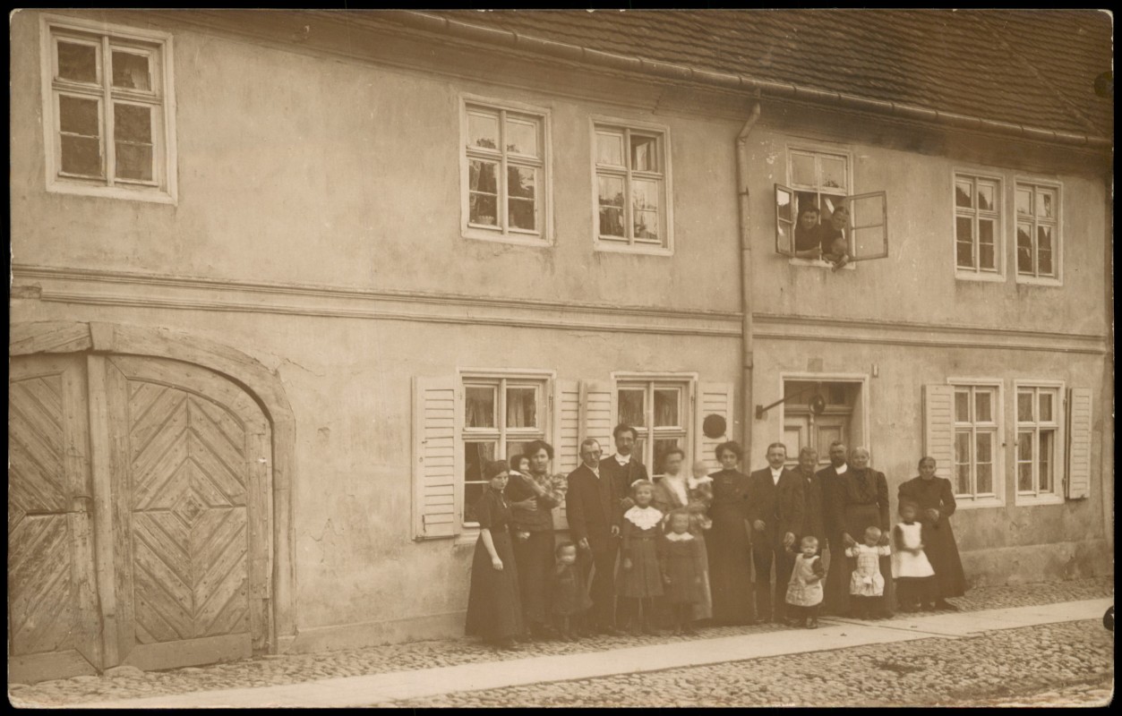 zoom: Image side vintage Postcard from 1910: Große Personengruppe vor einem Wohnhaus mit Holztor::