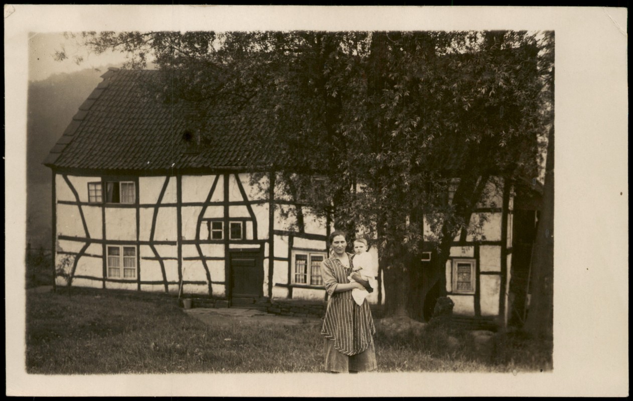 vergrößern: Bildseite historische Ansichtskarte von 1930: Fachwerkhaus mit Frau und Kind::