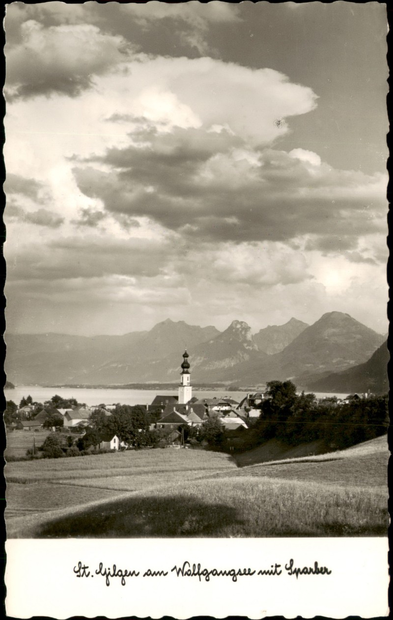 vergrößern: Bildseite historische Ansichtskarte von 1950: Blick über Wiesen auf den Ort mit Kirche vor See- und Bergkulisse:: Sankt Gilgen