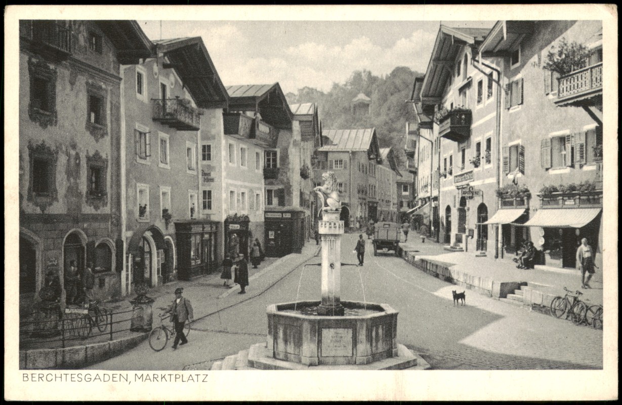 vergrößern: Bildseite historische Ansichtskarte von 1920: Marktplatz, Brunnen, Geschäfte, Mann mit Fahrrad:: Berchtesgaden